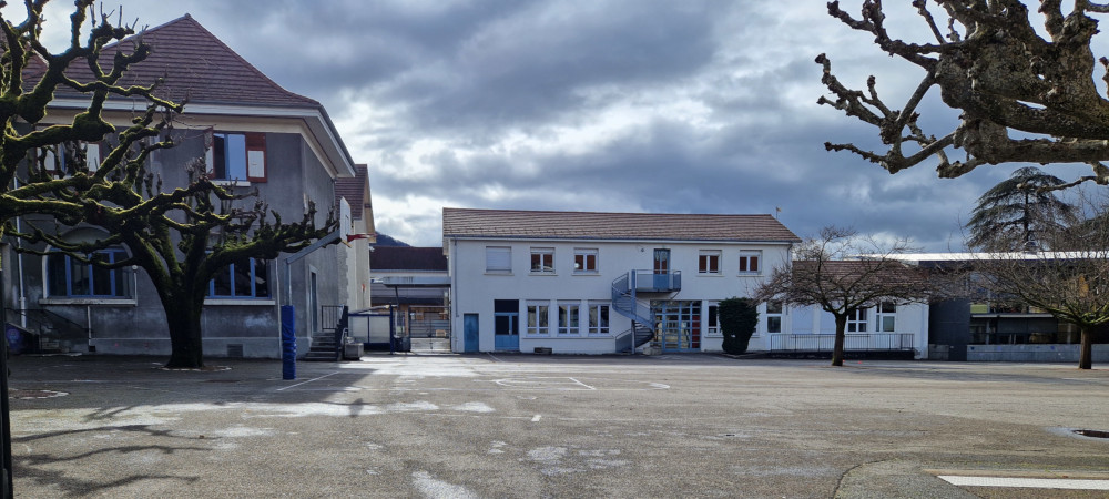 Cours de l'école Gustave Rivet quasi entièrement bétonnée avec très peu d'arbres
